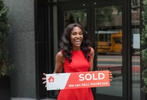 real estate agent holding sold sign