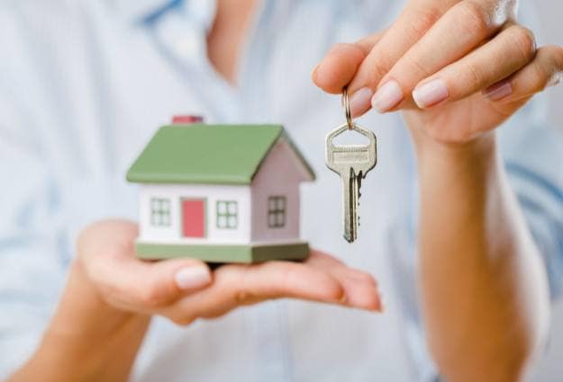 woman holding house with key
