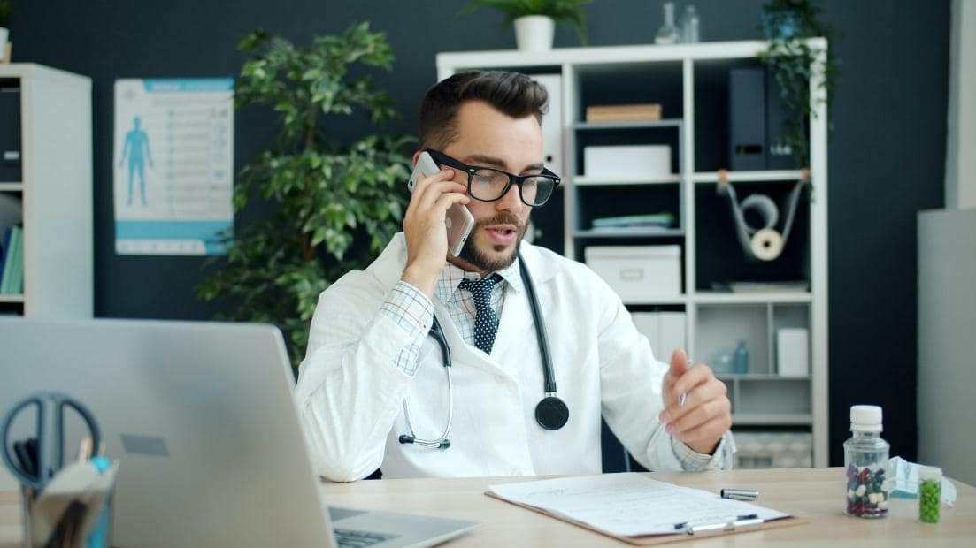 Medical professional speaking on the phone in a clinic office.