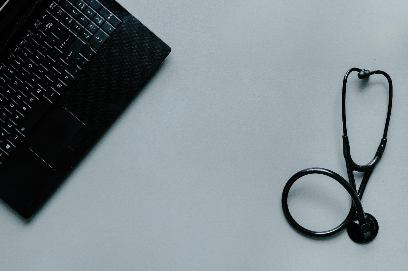 Stethoscope next to a laptop