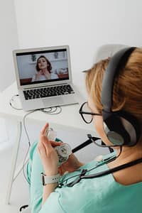 Doctor holding medication during video call while patient discusses sinus symptoms