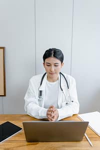 Doctor sitting in front of a laptop during a virtual medical appointment