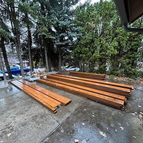 Pressure-treated framing ready for deck construction on wet ground after recent rain in Spokane, Washington.