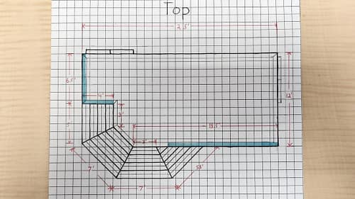 Top view of a deck design drawn on graph paper, including dimensions, step plans, and handrail details.