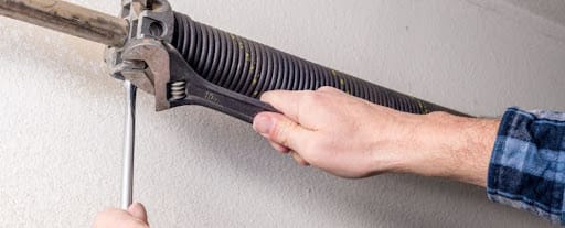 man repairing garage door spring