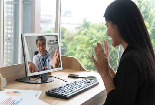 Woman speaking to doctor through computer