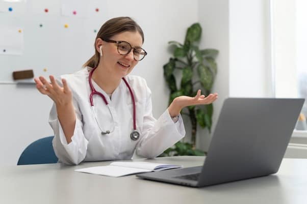 An online doctor consulting with a patient via laptop.