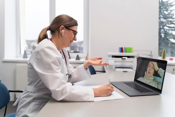An online doctor speaking with a patient by laptop.