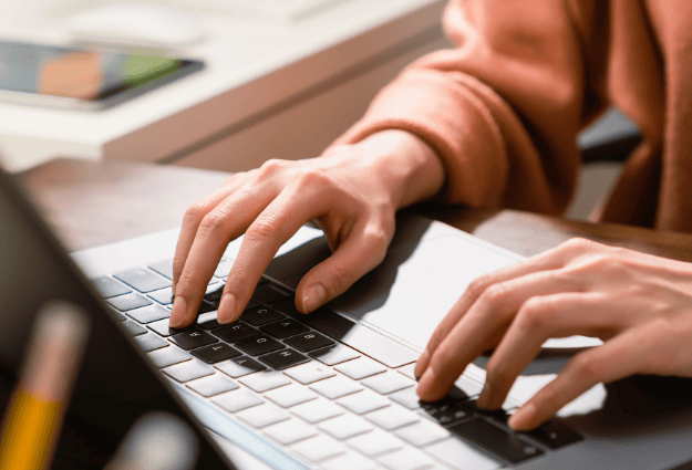 hands typing on laptop keyboard