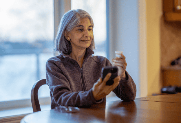 older woman looking at prescription bottle