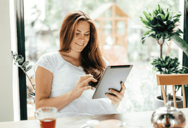 woman smiling using tablet