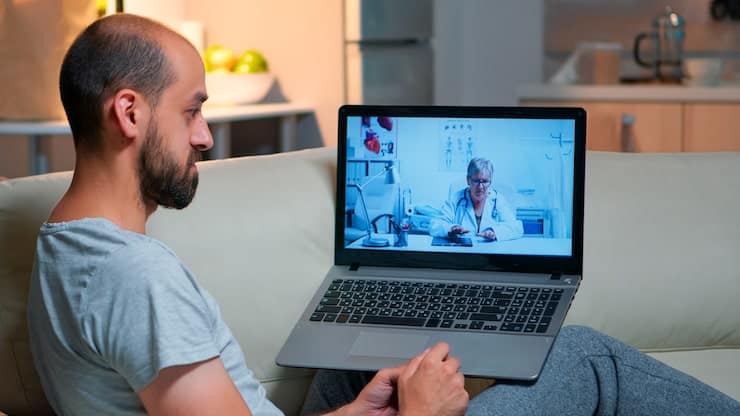 A man speaking with a doctor during an online video consultation.