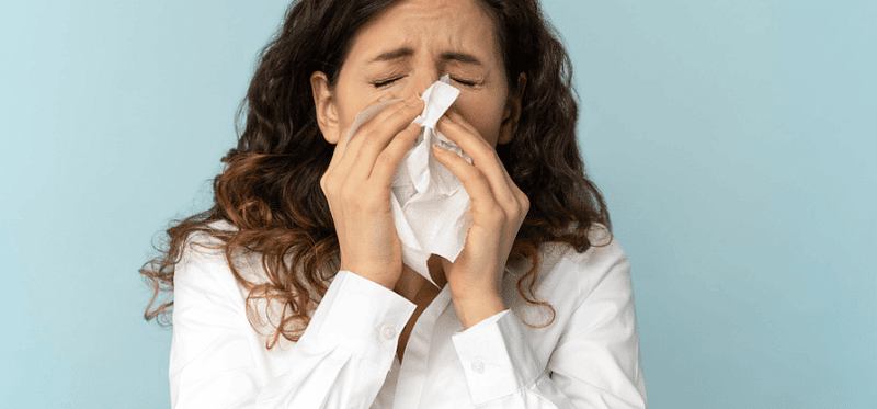 woman blowing nose in tisue