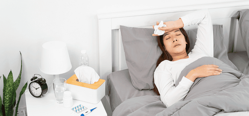 woman feeling sick in bed