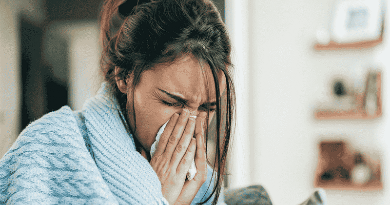 woman blowing nose in napkin