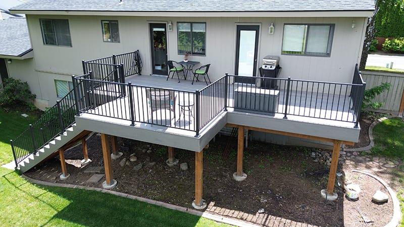 An elevated second-story deck adorned with outdoor furniture, overlooking a tidy backyard, exemplifying the clientele we serve with pride.