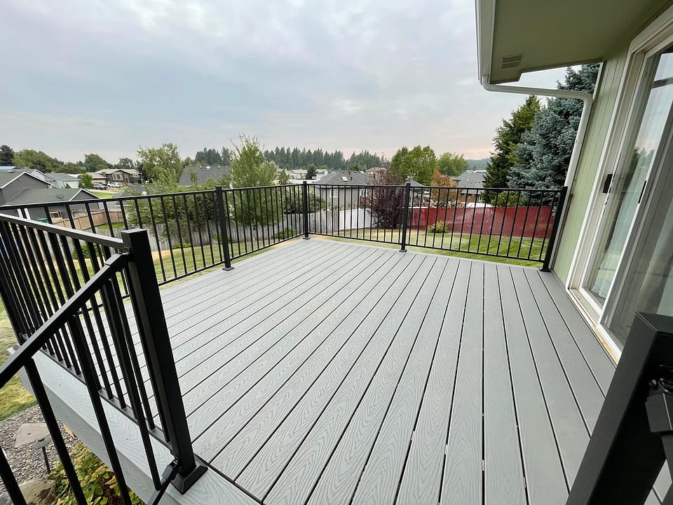 Gray Trex composite deck with hidden fasteners, freshly rebuilt on a cloudy day.