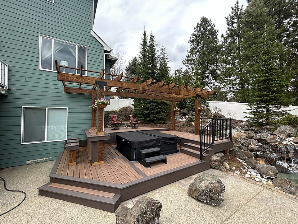 Custom deck around a hot tub, pergola, and bar