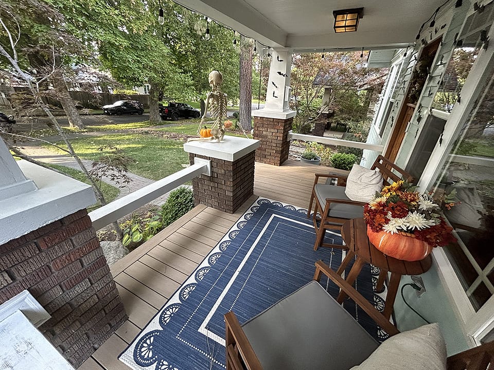 Front porch featuring outdoor decorations and furniture chosen by the homeowner.