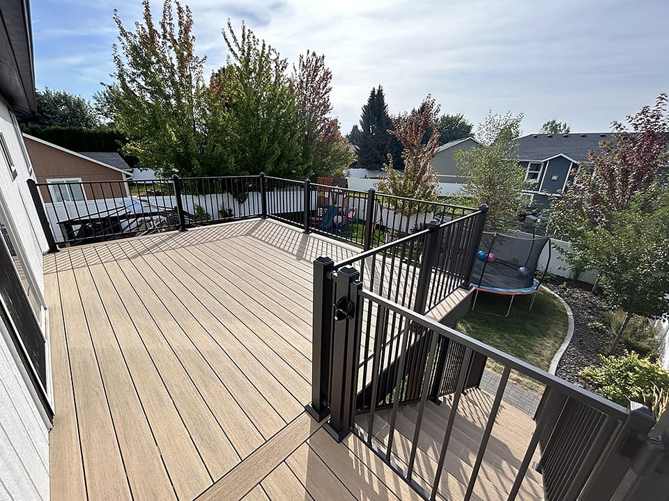 Stunning back deck built with teak-colored composite decking for a timeless look.