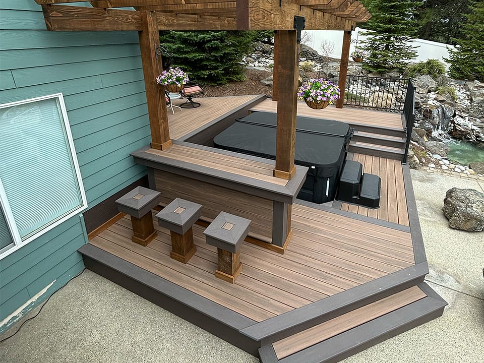 A deck featuring a bar and bar benches for outdoor entertaining.