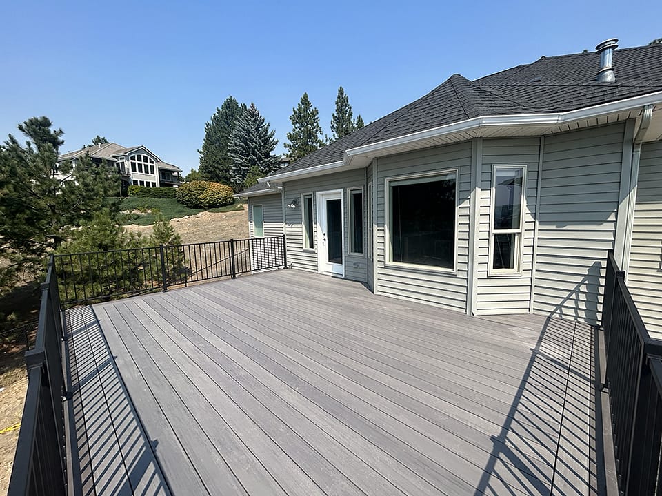 Spacious back deck attached to a home, designed for outdoor living and relaxation.