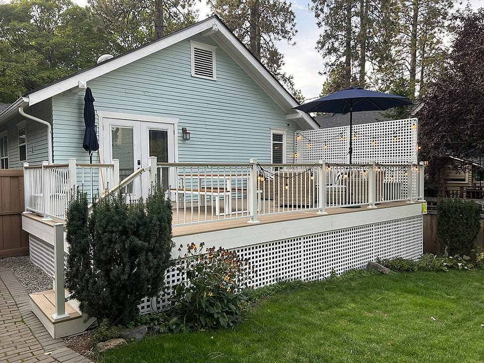 Large custom deck featuring white skirting and a privacy wall for added elegance and seclusion.