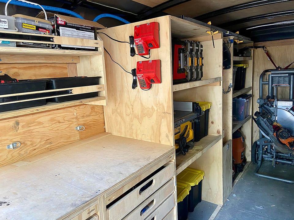 A professional deck builder’s tool trailer featuring built-in shelves stocked with a wide variety of tools essential for constructing a deck.