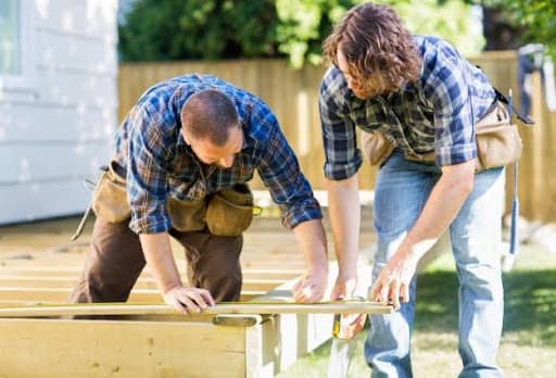 Two people building a deck