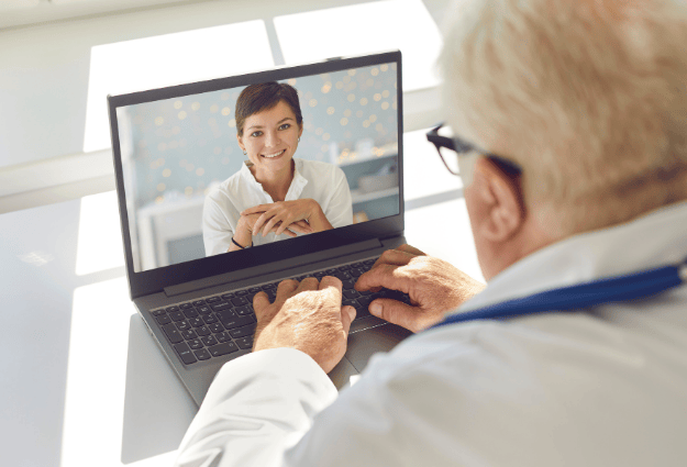 female doctor smiling through laptop video call