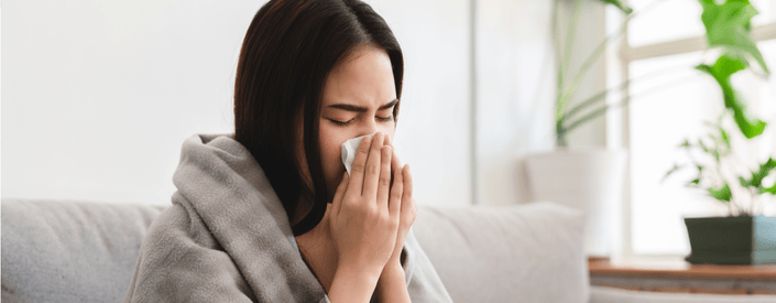 woman blowing nose in tissue