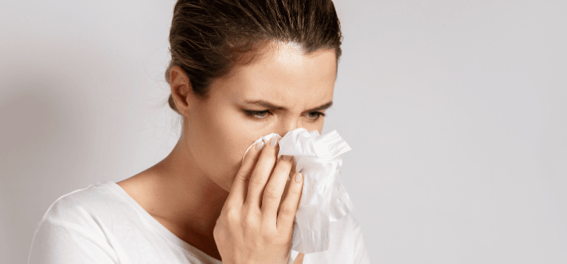 woman blowing nose into tissue