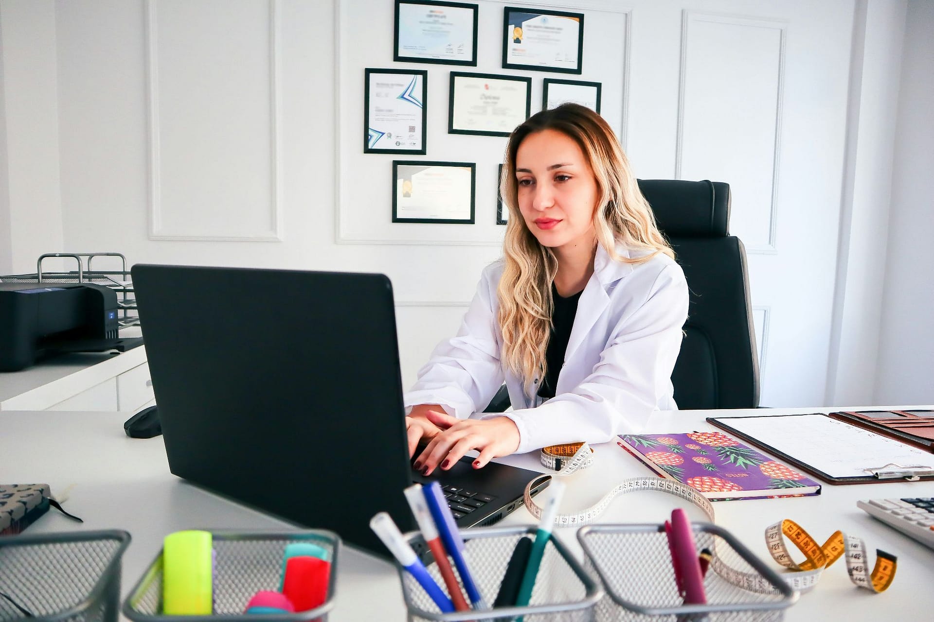 Medical provider working on a laptop in a clinic office.