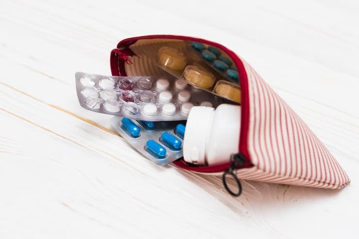 Prescription medications and travel health supplies packed in a small travel bag.