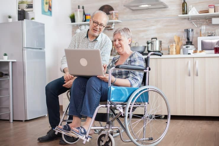 A woman in a wheelchair participating in an online medical consultation from home.
